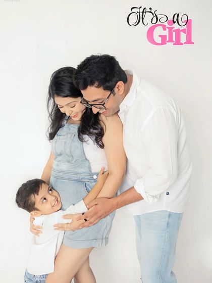 A fun and casual family announcement for a baby girl. The denim outfits and the big brother's curious look make this a relaxed and authentic family portrait.