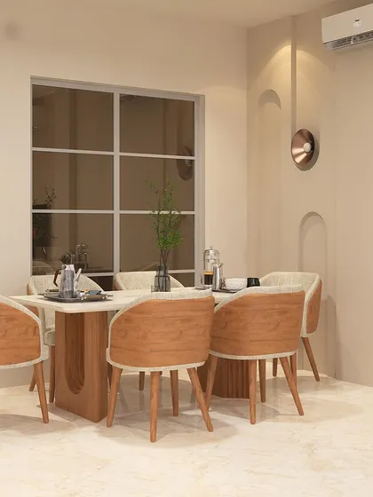 This dining area, designed for a project in Tata Primanti, features warm wood tones in the chairs and table base. The arched wall niches and simple decor create a space that is minimalist and inviting.