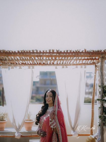 A wide shot of a bride on a rooftop, with the city skyline in the background.