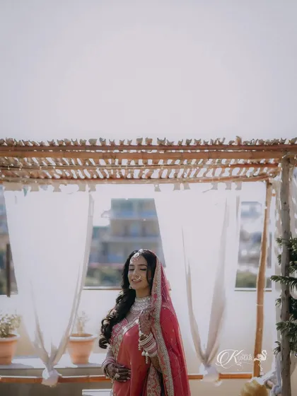 A wide shot of a bride on a rooftop, with the city skyline in the background.