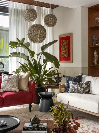 For the living room at The Collector's Retreat, I wanted to create a space that felt both curated and deeply comfortable. The bold red sofa adds a burst of energy, while the layered textures, art pieces from the client's collection, and oversized plants come together to tell a rich, personal story. This is a room designed for lively conversations and quiet afternoons.