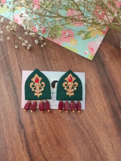 These hand-painted earrings are shaped like traditional arches and feature intricate designs with bead drops. They are available in both green and red, perfect for festive or wedding attire.