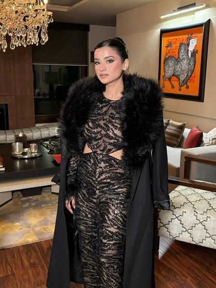 The winter party look is complete with a chic faux fur-collared coat. The glamorous makeup holds its own and completes the ensemble.