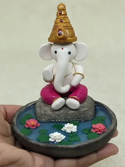 This is one of my favorite pieces to create. A miniature Ganesha, hand-sculpted from polymer clay, finding his peace in a serene lotus pond. Each tiny petal and the calm water effect is crafted to bring a sense of tranquility to your home.