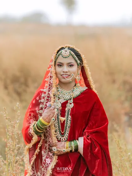 A beautiful outdoor portrait of a bride in a rich red velvet lehenga, her traditional Muslim bridal look is absolutely breathtaking.