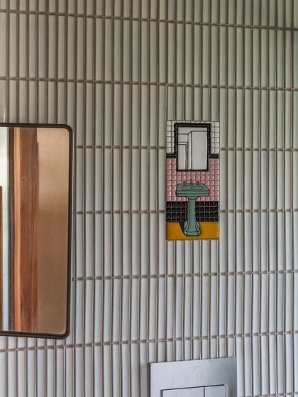 Another beautiful, hand-picked tile from the clients' collection, placed thoughtfully against a backdrop of simple, vertical tiles in the bathroom. These small details add layers of personality and memory to the home.