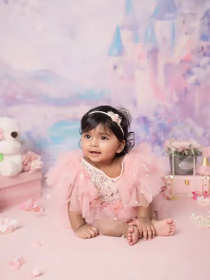 A sweet, candid moment from the princess session. The soft pinks and purples of the set design complement her adorable tulle dress.