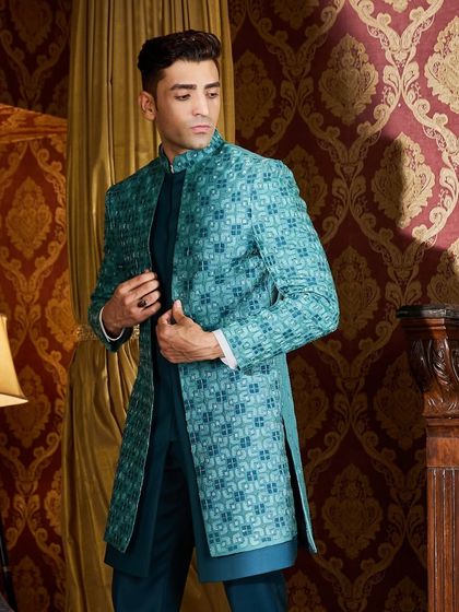 Make an entrance in this stunning teal green Indo-Western outfit. The jacket features a geometric tonal threadwork pattern, layered over a matching teal kurta for a vibrant, monochrome look.