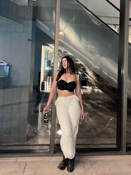 A full-length view of the black crop top and white pants, a comfortable yet stylish look for a music event.