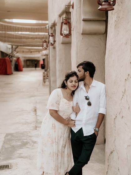 A tender forehead kiss in a rustic alley, capturing the warmth and affection between the couple.