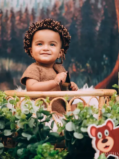 A happy little explorer in our Jungle Book themed shoot. The setup includes lush greenery, friendly animal cutouts, and a cozy basket for the perfect wild adventure portrait.