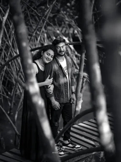 A timeless black and white portrait of the couple on a bridge, creating a classic and romantic mood.