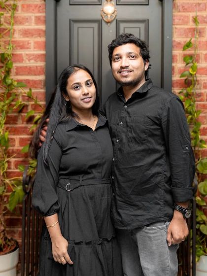 A couple posing in front of our iconic 221B door, surrounded by lush greenery. It's a little piece of London right here in Hennur.