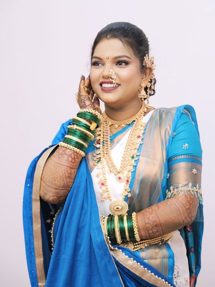 The bride adjusting her earring, giving a good view of her hairstyle and the floral accessories.