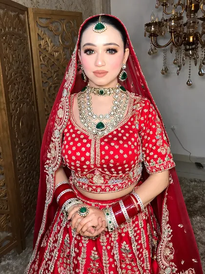 A full view of the bride's jewelry, including the choker, layered necklace, maang tikka, and matching earrings.