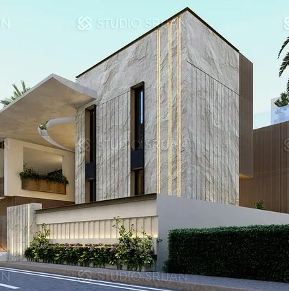 The front elevation of the Coimbatore villa, showcasing a powerful facade with natural stone cladding and a dramatic cantilevered roof. Integrated lighting within the stone panels adds a layer of sophistication to the design.