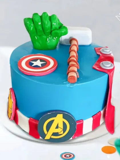 An epic Avengers cake featuring Hulk's fist, Thor's hammer, and Captain America's shield. This design brings together the power of Marvel's mightiest heroes for one legendary birthday.