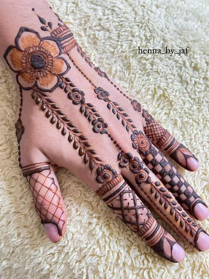 A full view of the hand with multi-patterned fingers, anchored by a large flower at the wrist.