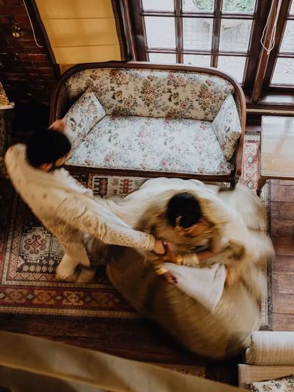 An artistic, high-angle shot of the couple in a vintage-style room, capturing a moment of playful interaction.