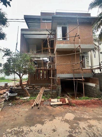 The Divyadarshan residence in its early construction phase. This image shows the skeleton of the house, with scaffolding in place as the mud block walls are being built.