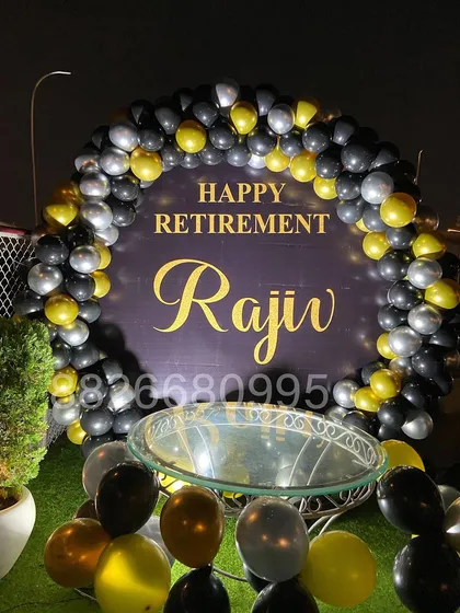 I designed this personalized retirement party decoration for an outdoor event. It features a custom backdrop with the retiree's name and a sophisticated black, gold, and silver balloon arch, perfect for corporate farewells.