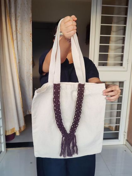 This is my cotton tote bag featuring a decorative macrame belt. It's a sustainable and stylish alternative to plastic bags, perfect for everyday use.