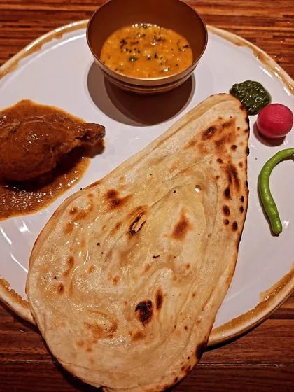 A classic North Indian thali-style plate at Loya, featuring a rich curry and freshly baked naan.