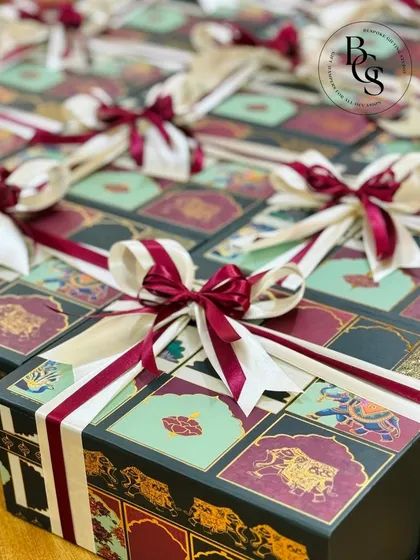 A display of our Indian-themed festive boxes, perfect for weddings or cultural celebrations. The intricate design on the boxes, paired with rich burgundy and cream ribbons, offers a touch of royal elegance.