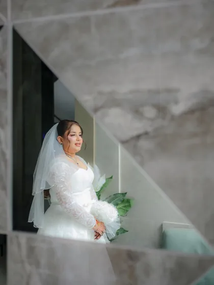 A creative portrait of a Christian bride captured through a geometric mirror, adding an artistic and modern touch to her wedding photos.