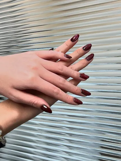 A beautiful set of deep, wine-red nails. The almond shape is classic, and the color is rich and luxurious.