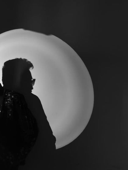 A creative black and white portrait using a single light source to create a dramatic shadow.