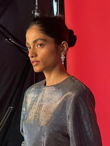 Another portrait from the same BTS series, capturing the model's profile and the elegant silver dress.