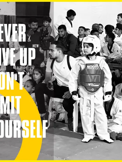 Never give up, don't limit yourself. A young student in full Taekwondo gear stands ready for competition, showing focus and determination.