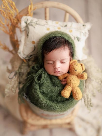 I love how this setup turned out. The combination of the olive green wrap, the mustard teddy bear, and the rustic props creates a beautiful, earthy feel.