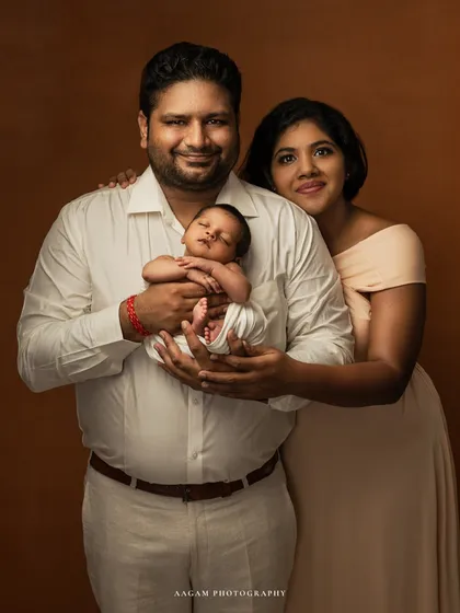 The first family portrait. This image captures the complete circle of love, with both parents beaming as they hold their new baby.