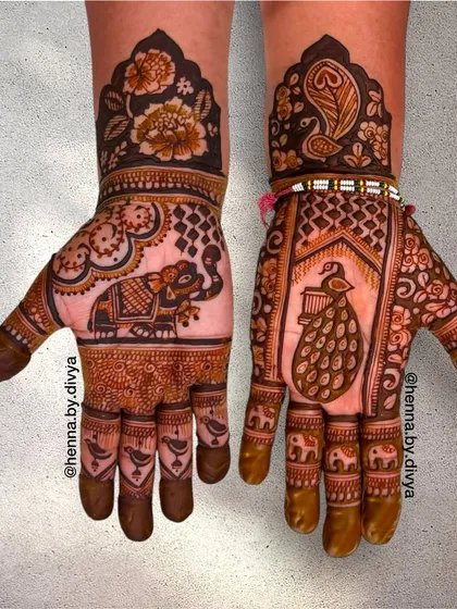 A rich design featuring a large elephant on one palm and a peacock on the other. The wrists are decorated with floral patterns and peacock feather motifs.
