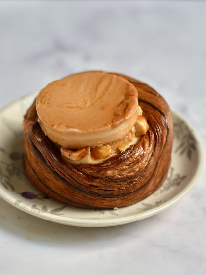 Our Caramel Custard Croissant is a tribute to a classic Bombay dessert. A flaky croissant cup is filled with caramel custard mousse and candied peanuts, then topped with a perfect little caramel custard.