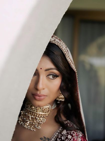 A creative shot that captures the mystery and elegance of the bride. The focus on her eye makeup, with its sharp wing and soft shadow, adds a touch of poetry to her look.