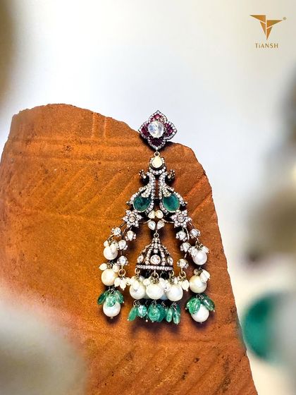Polki diamonds paired with lush emeralds, delicate pearls, and meenakari detailing come alive in this statement jhumka inspired pendant from the Whispers of the Earth collection.