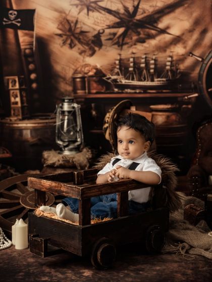 A thoughtful moment from our pirate, sitting in his crate amidst a backdrop of maps, lanterns, and treasure.