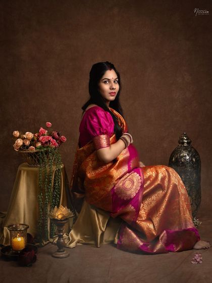 A portrait that feels like a timeless painting. The rich colors of the saree, the soft candlelight, and her serene expression come together to create a truly artistic memory.