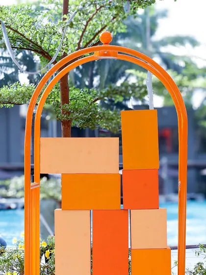 A modern art installation in shades of orange, serving as a unique decor piece by the poolside for the Mexican-themed Haldi.