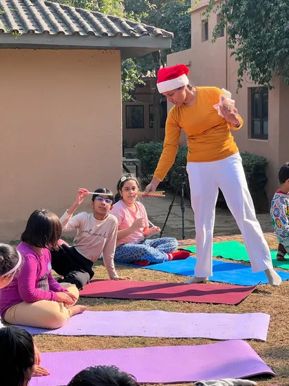 A teacher in a Santa hat leads a kids' yoga class outdoors. We love to incorporate festive fun into our special holiday retreats.