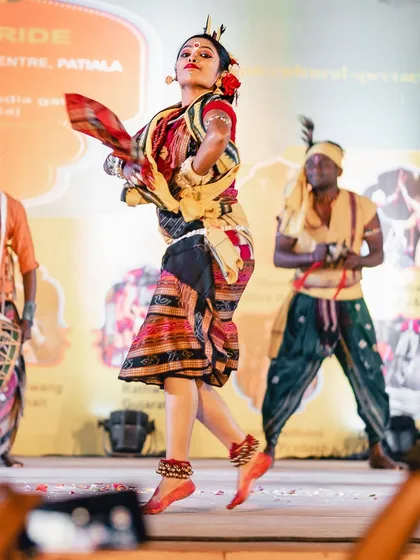 A dancer is captured mid-motion, her colorful traditional dress flowing around her. This shot freezes a dynamic moment, highlighting the beauty of the costume and the energy of the dance.