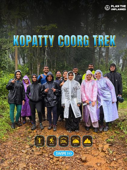A group in raincoats on a muddy trail during the Kopatty Coorg trek, fully embracing the monsoon adventure.