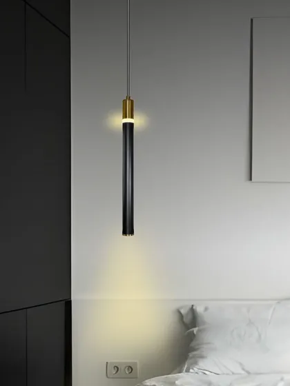 A single black and gold pendant light can be a simple yet effective lighting solution for a bedside. It provides focused downward light for reading and adds a touch of modern elegance.