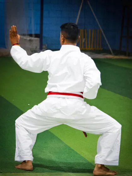A correct stance is the foundation of all power in karate. This rear view shows the proper alignment and distribution of weight in a fundamental stance, essential for both stability and explosive movement.