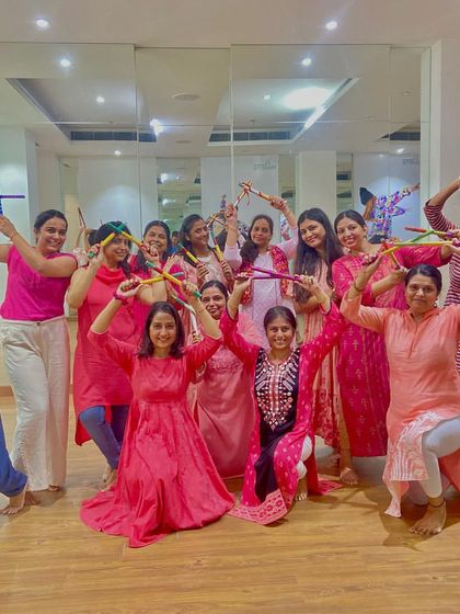The ladies of the Mahagun Moderne Dandiya workshop posing with their dandiya sticks. This class focused on formations and partner work for a complete performance.