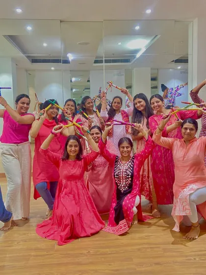 The ladies of the Mahagun Moderne Dandiya workshop posing with their dandiya sticks. This class focused on formations and partner work for a complete performance.