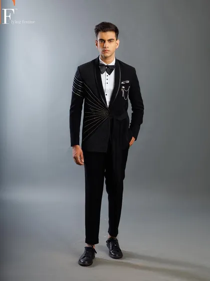 A studio shot of a model in our unique draped tuxedo. The jacket features an asymmetric design with golden beadwork, creating a truly avant-garde look.